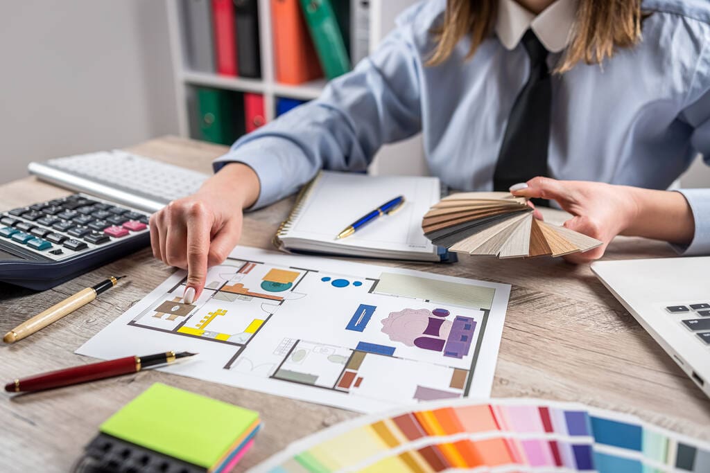 Female designer architect using color swatch for renovation home with blueprint.